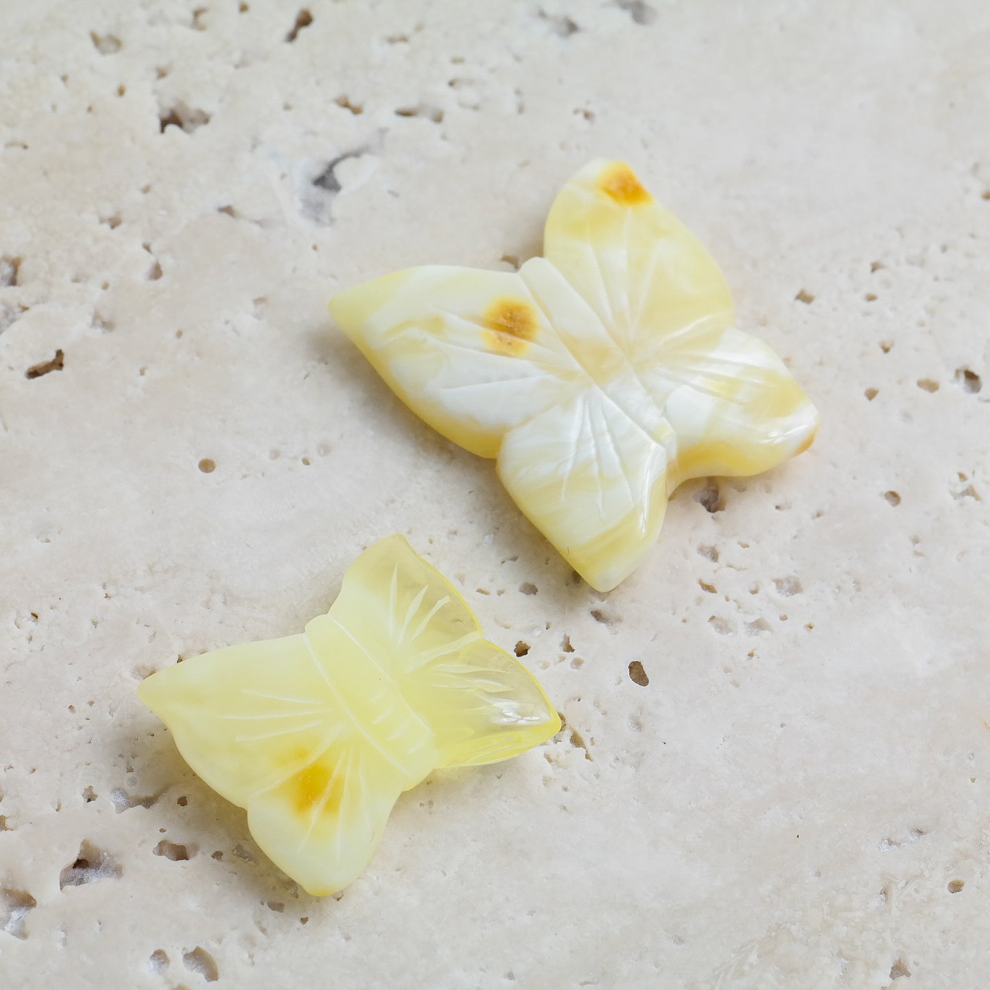 Hand carved white amber butterfly figurines