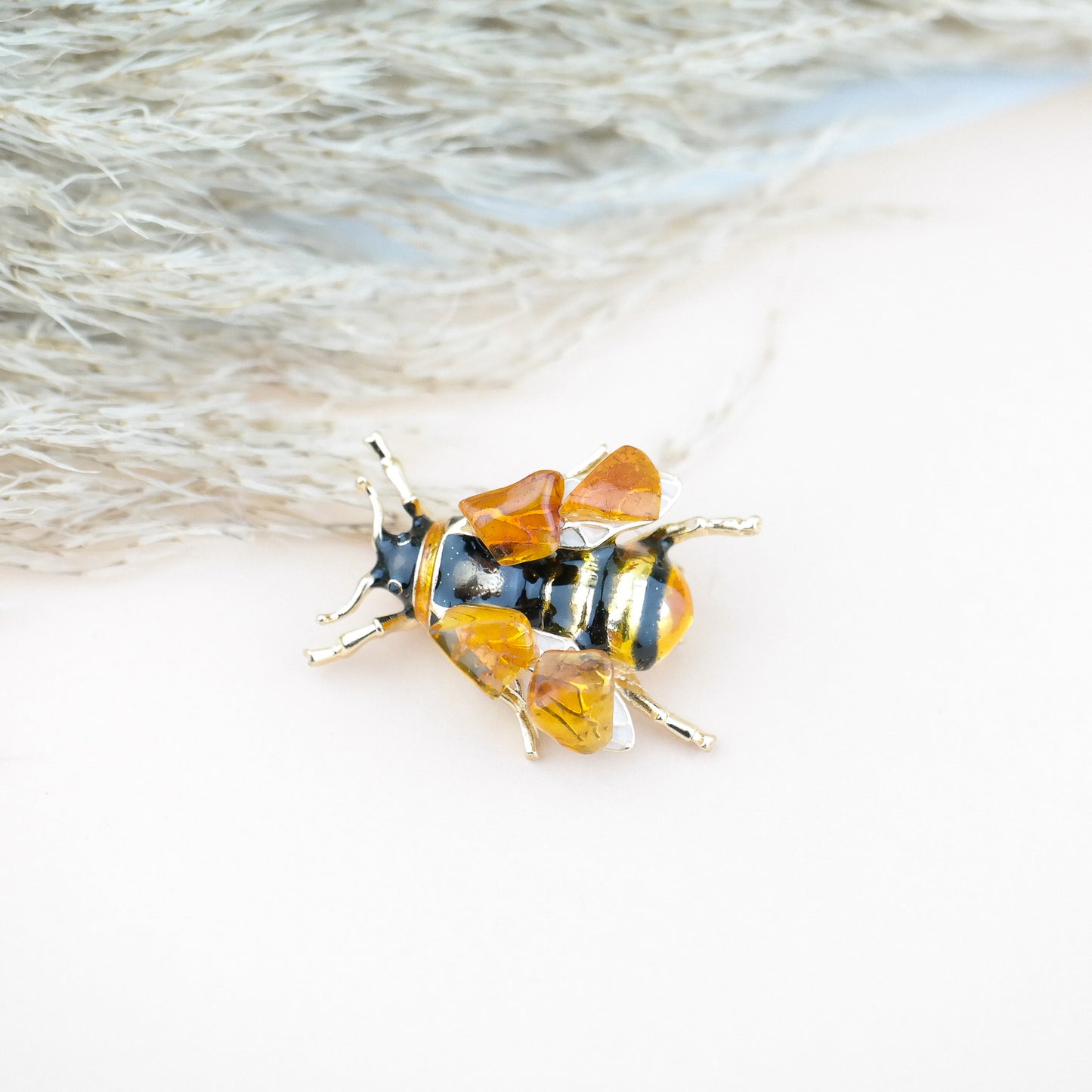 Bee brooches with natural amber