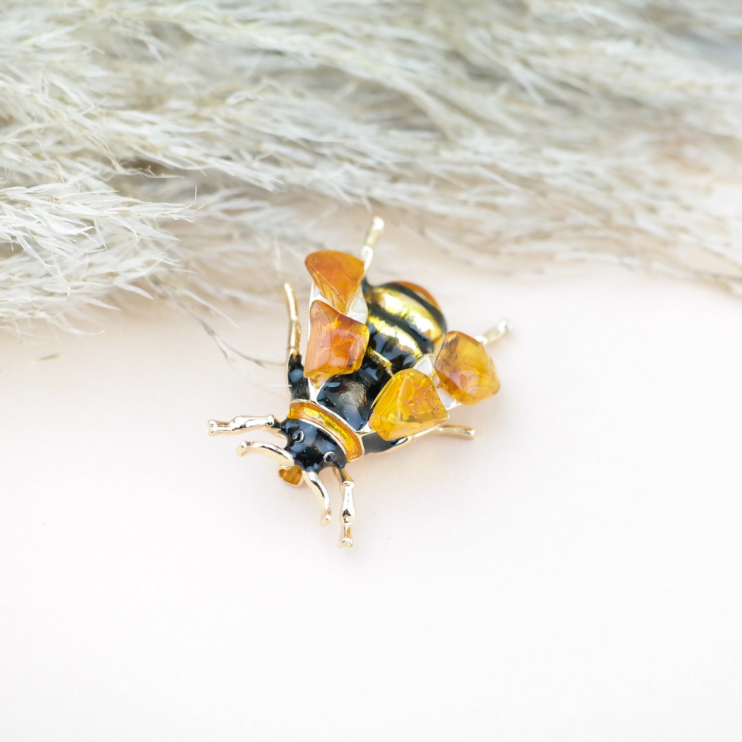 Bee brooches with natural amber