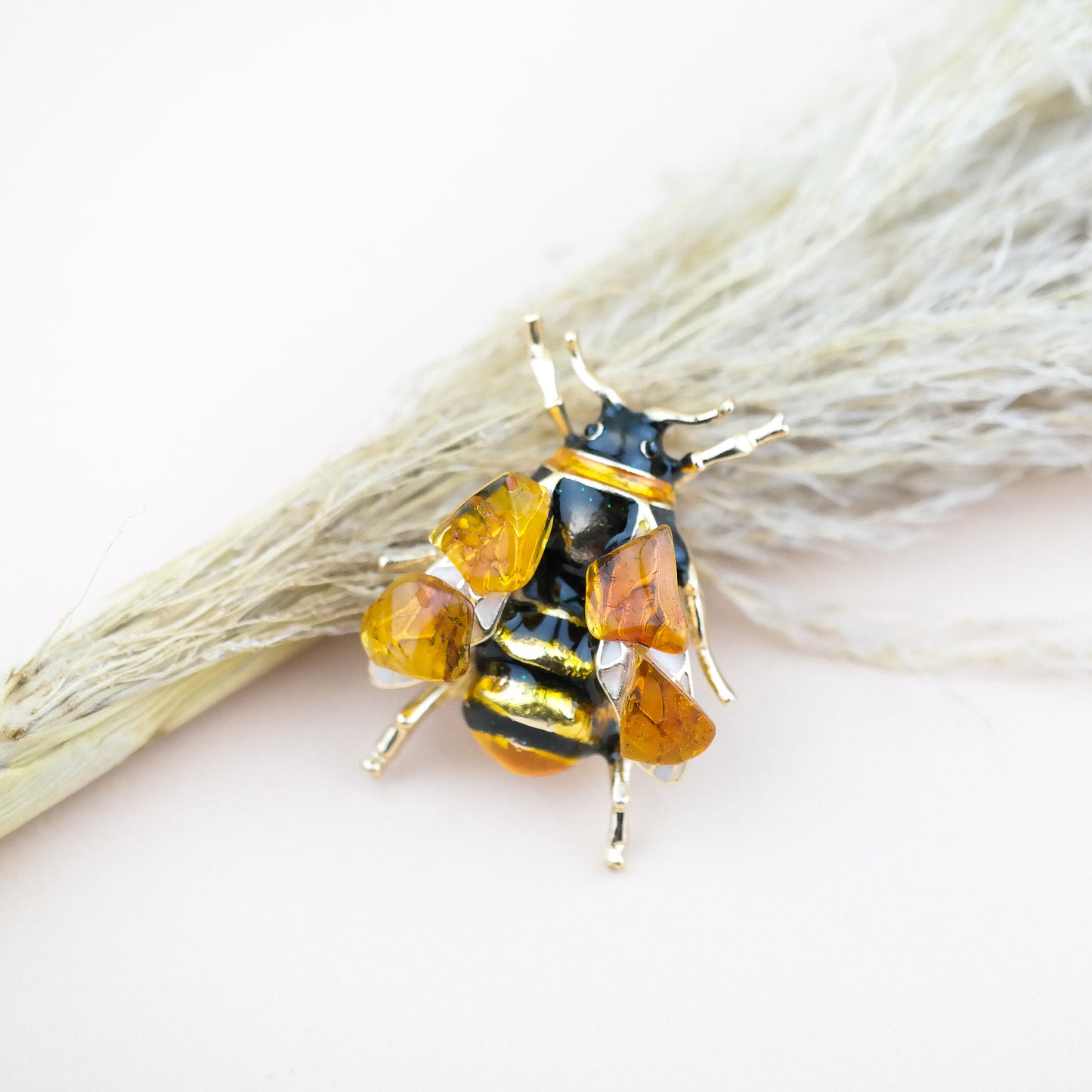 Bee brooches with natural amber
