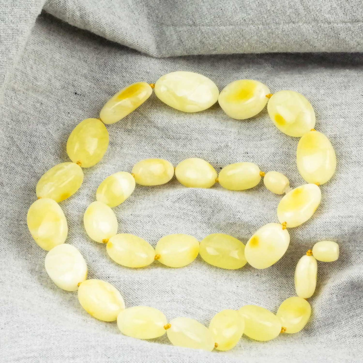 Amber necklace from milky yellow, bean shaped amber beads