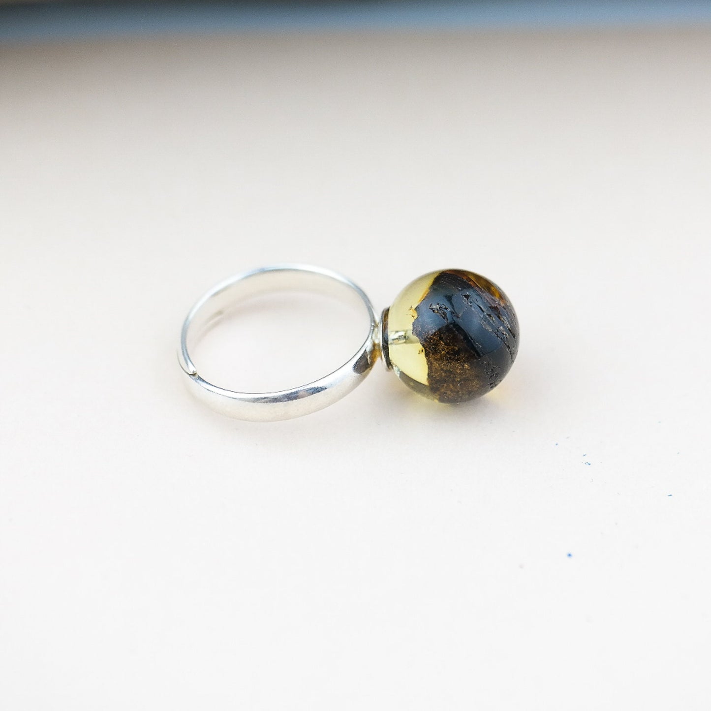 Adjustable silver ring with natural amber bead