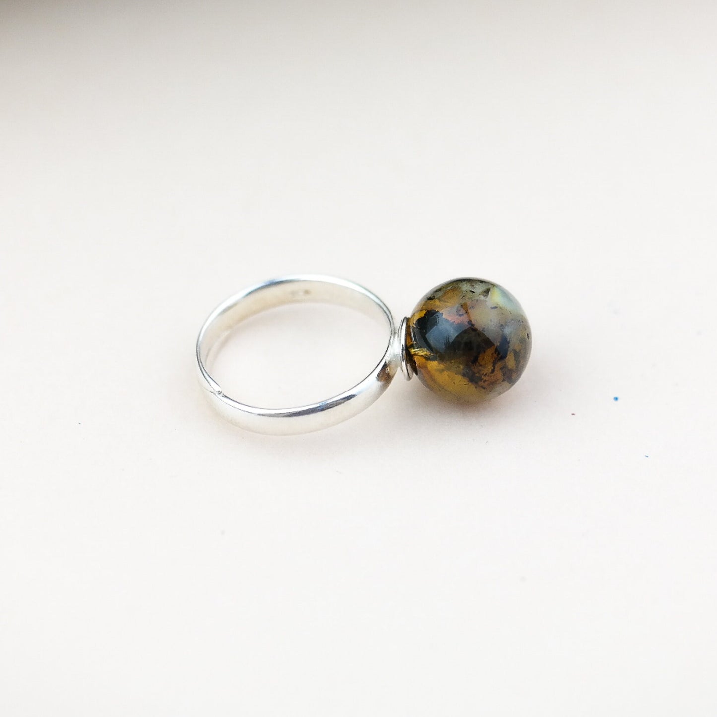 Adjustable silver ring with natural amber bead