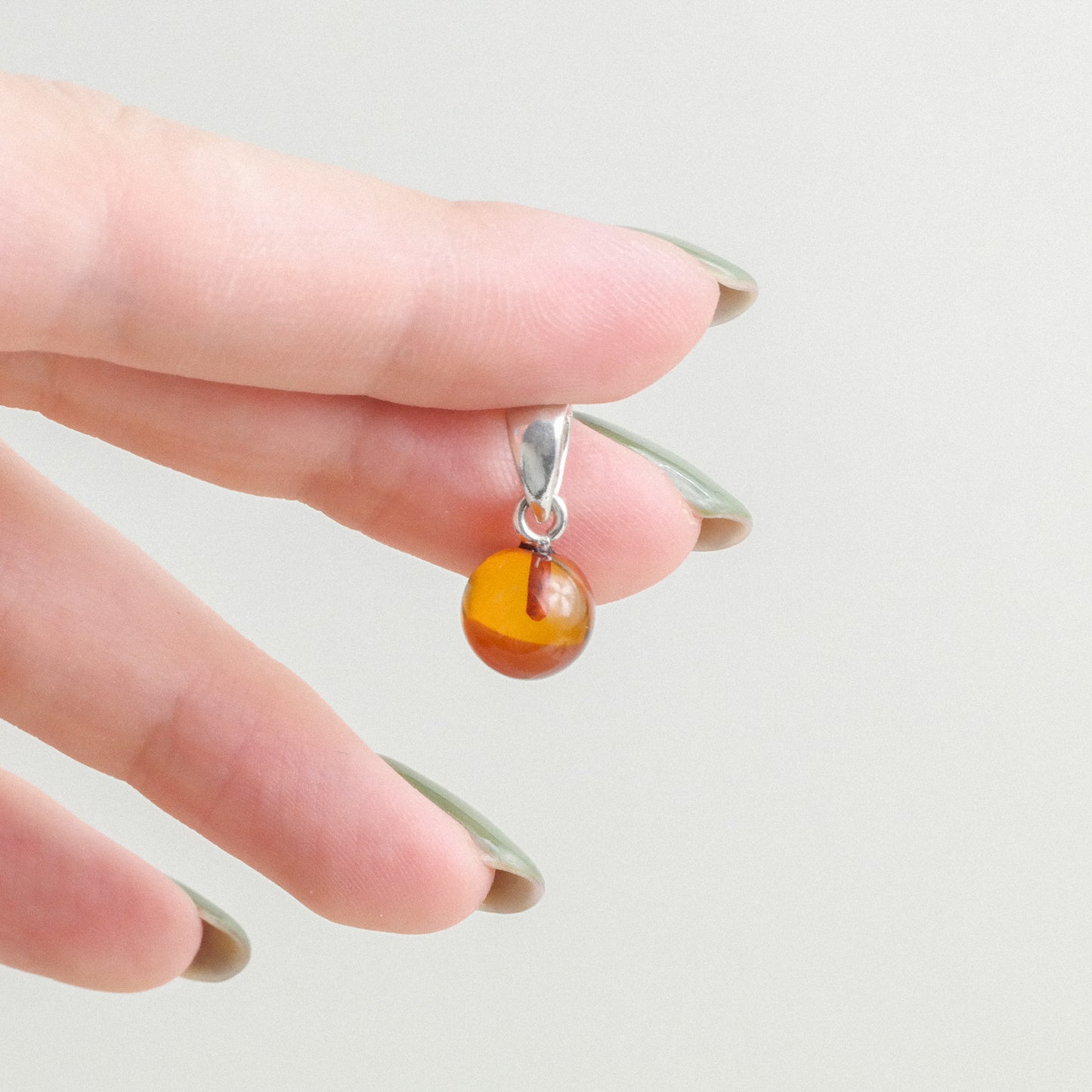 Chic and tiny natural Baltic amber ball pendant