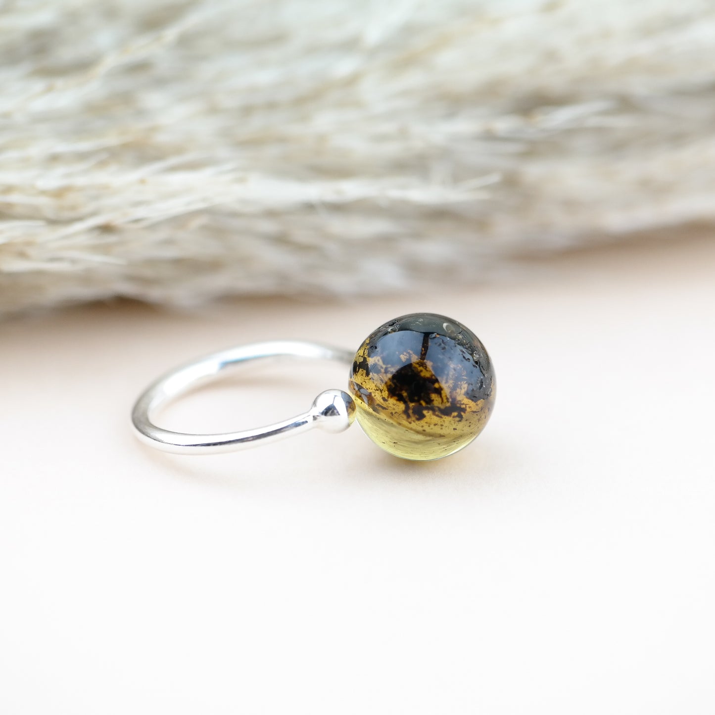 Adjustable silver ring with natural green amber bead