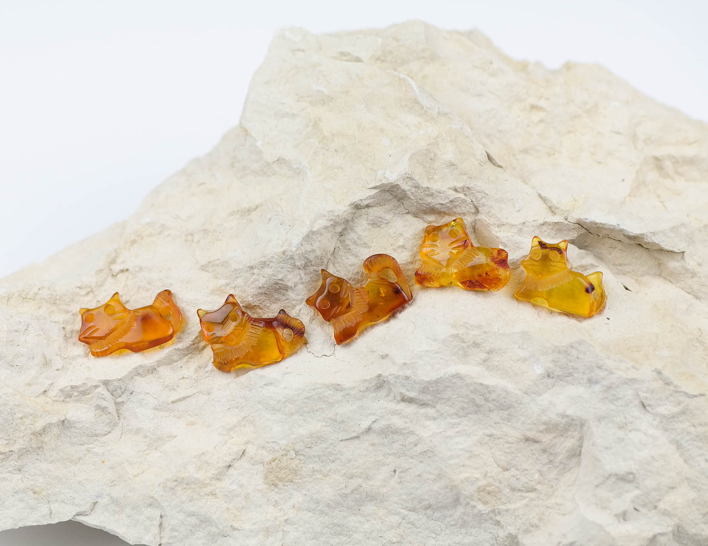 Hand carved kitten figurines from natural Baltic amber, perfect for jewelry making